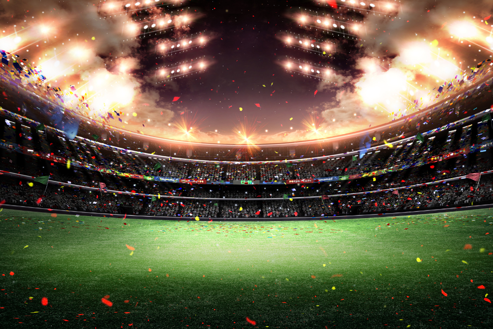An expansive open air stadium with lights on at night, smoke cannons and confetti in the air 