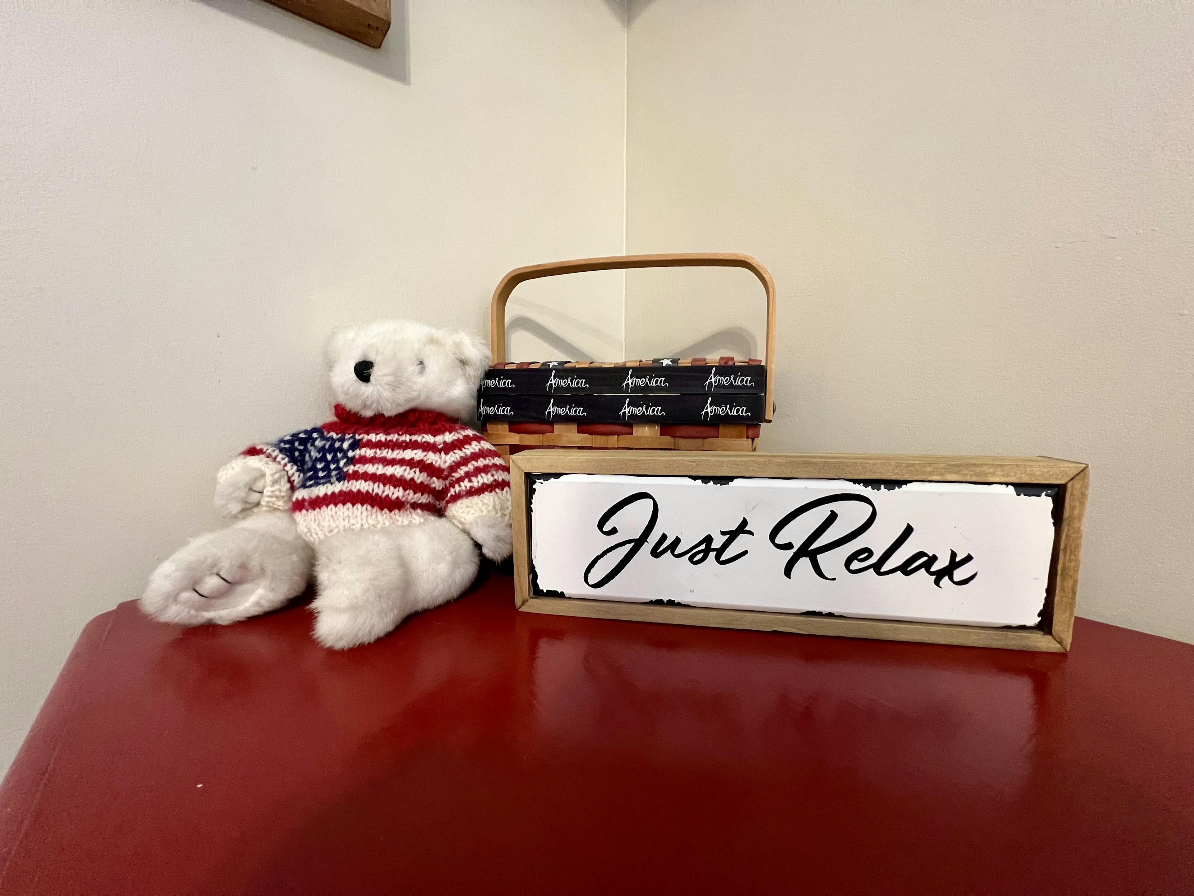 Red dresser with bear, basket and sign that says just relax